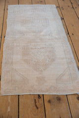 Distressed vintage Oushak rug texture with soft ivory, platinum, and pale sand tones.