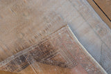 Vintage distressed Oushak rug corner showing pile wear, woven foundation, and intact selvage.