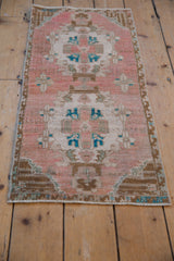 Distressed Oushak rug detail: worn dusty rose field, ivory central motif, and turquoise accents.