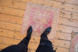 Distressed vintage Oushak square rug, pale raspberry and ivory abrash with floral patterns.