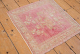 Distressed pink and ivory Oushak rug texture, with visible knot heads and abrash.