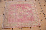 Distressed pink and ivory Oushak rug corner showing original side selvage.