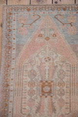 Distressed vintage Oushak rug pile with pastel pink and muted blue tones.