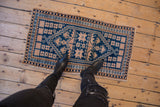 Cobalt blue and ivory geometric stepped medallion on a vintage Oushak rug.