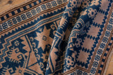 Folded texture of a vintage Oushak rug in cobalt blue, ivory, and brown geometric patterns.