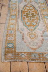 Soft, distressed texture of the vintage Oushak runner, with pale bronze border and ivory fringe.