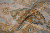Hand-knotted, distressed Oushak runner with worn ivory, bronze, and teal stepped patterns.