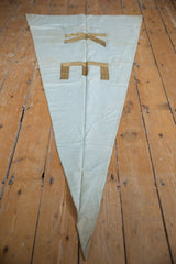 Pointed bottom of vintage K E banner flag showing fabric creases and light stains.