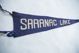 Antique Saranac Lake felt banner, blue texture with white SARANAC block letters.