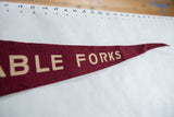 Close-up of the white lettering on the tapering end of the burgundy felt pennant.