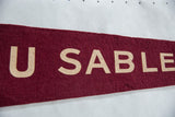 Detail of the vintage lettering and matted texture on the burgundy felt pennant.