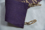 Corner detail of purple vintage felt banner showcasing texture, stitching, and beige ties.
