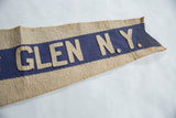 Vintage felt pennant detail: hand-stitched beige 'GLEN N.Y.' letters on blue with aged texture.