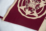 Hand-sewn felt appliqué showing the Mind Spirit Body design on a burgundy flag.