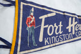 Blue felt texture of vintage Fort Henry pennant with yellow trim and ties.