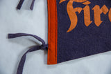 Vintage Firestone felt flag, left edge with orange trim, dark blue ties, and distressed orange logo.