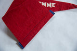 Close-up detail of the vintage red felt banner with blue stitched edge.