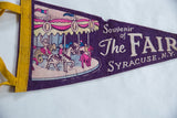 Vintage purple felt pennant detail: merry-go-round graphic, yellow border, and text.