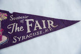 Purple felt banner detail with 'The FAIR SYRACUSE' text and minor top edge fraying.