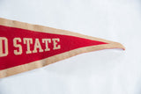 Vintage Cortland State felt pennant's pointed tip, showcasing red felt and aged tan border.