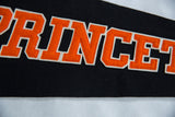 Textured close-up of orange felt Princeton letters with white outline on black banner.
