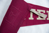 Vintage burgundy felt pennant with beige EXET letters and textured stitching.