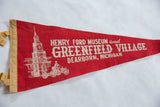 Vintage red felt pennant's tan binding, light creasing, and partial building graphic.