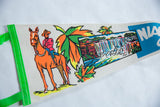 Angled view of a vintage felt pennant focusing on the soldier on horseback and colorful waterfall graphics.