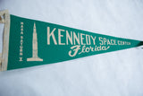 Green felt pennant with cream 'Kennedy Space Center Florida' lettering.