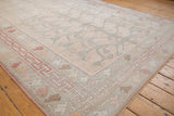 Distressed vintage Oushak rug's pale rose tree of life design and playful geometric raspberry border.