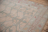 Distressed Oushak carpet with rose field, teal tree-of-life motif, and playful geometric border.