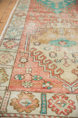 Distressed vintage Oushak runner's soft red, ivory, turquoise floral border detail.