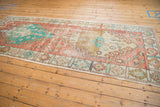 Distressed Oushak rug runner, soft red and turquoise floral border, with worn ivory fringe.