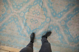 A personal perspective looking down at the distressed Soumac rug's geometric pattern in blue and mauve.