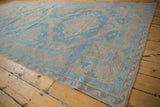 Angled perspective of a vintage distressed Soumac runner featuring pale denim blue geometric medallions and a zig-zag border.
