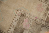 Oushak rug corner shows textured pile, faint dusty blush flower, and hand-knotted foundation.