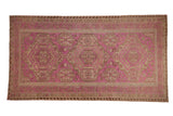 Vintage Soumac carpet with a triple medallion design on a distressed fuchsia field with sand and brown geometric patterns.