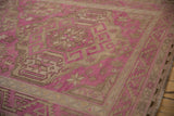 Angled view of a vintage Soumac carpet's geometric starburst motifs in fuchsia and sand.
