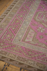 Detailed corner of a vintage Soumac carpet with fuchsia, sand, and brown geometric borders.