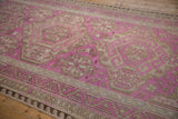 Angled perspective of a vintage Soumac showing fuchsia geometric motifs and flatweave texture.