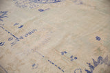 Distressed Oushak rug, showing cobalt blue motifs on abrashed field with faint foundation visible.