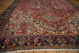 Vintage Heriz rug's navy trefoil border and field of jade green geometric motifs.