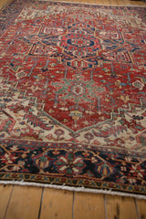 Brick red geometric vinery field and navy blue floral border on a vintage Heriz rug.