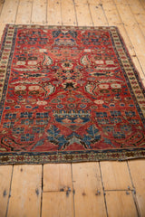 Unusual boteh paisley motifs with Herati-style fish on a cherry red Northwest Persian rug.