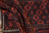 Madder root and navy geometric palmettes, latch contours on an antique Belouch rug.
