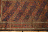 Worn lower border of a Vintage Belouch rug with navy and chestnut pawn motif.