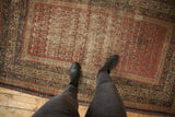 Serbend antique rug corner showing reciprocating pawn border and madder red boteh field.
