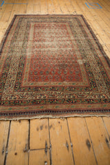 Antique Serbend rug: madder red boteh field, patterned borders, even wear visible.