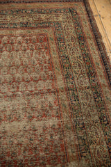 Antique Serbend rug's madder red boteh field, vine and pawn motif borders, showing tattered edge.