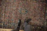 Vintage Persian Yezd rug showing muted rose field with scrolling vinery, border cartouches, and even wear.